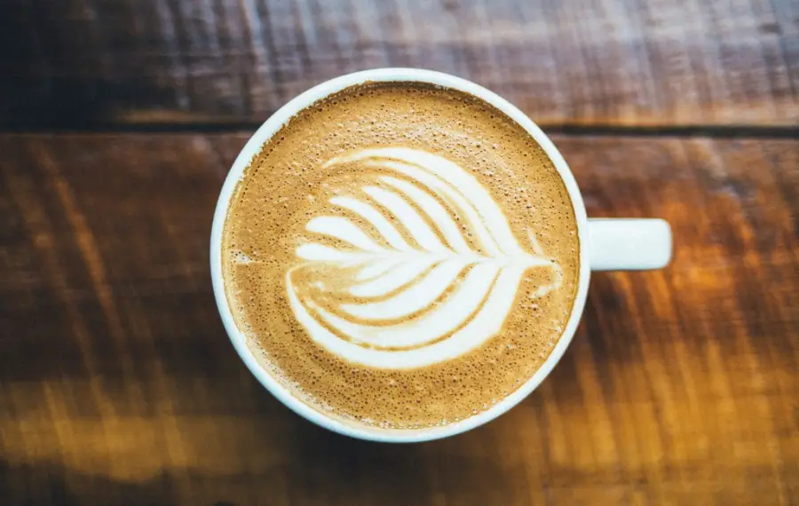 Latte-art í kaffibolla á tréborði